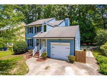 Charming two-story home boasts a well-manicured lawn, attached garage, and lovely curb appeal at 6104 New Market Way, Raleigh, NC 27609