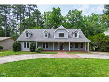 Charming gray two-story home featuring a welcoming front porch and well-manicured lawn at 7009 Brecken Ridge Ave, Raleigh, NC 27615