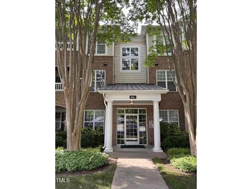 Attractive brick building featuring a covered entrance with white columns and manicured landscaping at 8041 Allyns Landing Way Way # 303, Raleigh, NC 27615