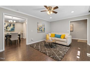 Inviting living room with hardwood floors and neutral decor, leading into dining area at 821 Stoneybrook Dr, Sanford, NC 27330
