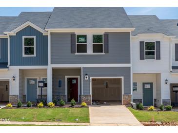 Charming two-story townhome featuring a garage, landscaped yard, and a welcoming front entrance at 1033 Winding Spring Dr, Mebane, NC 27302