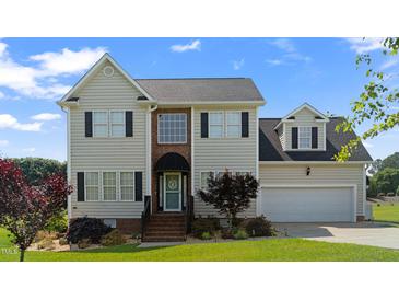 Inviting two-story home featuring a well-manicured lawn and attached two-car garage, creating perfect curb appeal at 115 Spring Branch Dr, Four Oaks, NC 27524