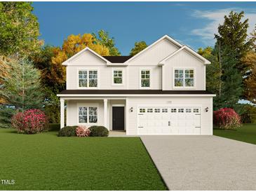Charming two-story home with white siding, a well-manicured lawn, and a two-car garage at 122 Jones Creek Ln, Lillington, NC 27546