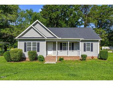 Charming single-story home with a well-manicured lawn, gray siding, black shutters, and a cozy front porch at 12449 W Pamlico St, Middlesex, NC 27557