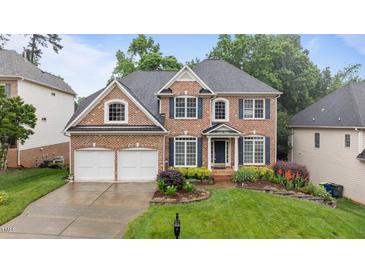 Charming two-story brick home with a well-manicured lawn and beautiful landscaping at 13121 Sargas St, Raleigh, NC 27614