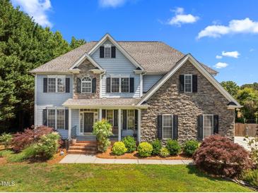 Charming two-story home with stone accents, mature landscaping, and a welcoming front porch at 1420 Norwood Crest Ct, Raleigh, NC 27614