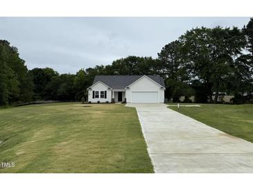 Charming one-story home with a well-manicured lawn and a long driveway leading to an attached garage at 188 Oakfield Trace Dr, Four Oaks, NC 27524