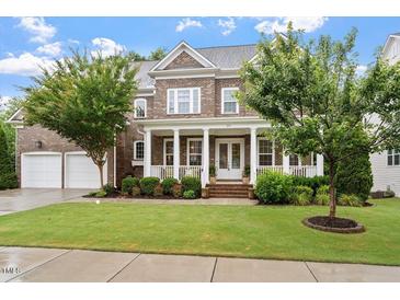 Charming two-story brick home with a welcoming front porch and well-manicured lawn at 213 Preatonwood Dr, Apex, NC 27539