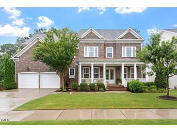 Beautiful two-story brick home with a welcoming front porch and manicured lawn at 213 Preatonwood Dr, Apex, NC 27539