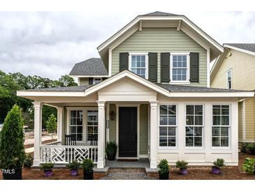 Charming home featuring a welcoming front porch, a black front door and manicured landscaping, creating a cozy curb appeal at 2641 Sidford Aly, Raleigh, NC 27608