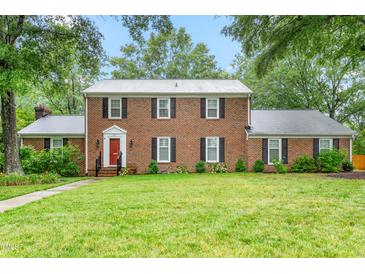 Charming brick home featuring a manicured lawn and vibrant red front door at 3027 Truitt Dr, Burlington, NC 27215