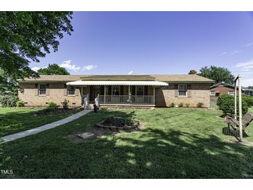 Charming brick home with a covered front porch and well-maintained lawn at 403 E Mcpherson Dr, Mebane, NC 27302