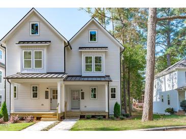 Charming two-story home featuring a welcoming porch, gray siding and black metal roof accents at 5053 Lundy Dr # 101, Raleigh, NC 27606