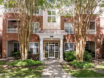 Beautiful brick building featuring manicured landscaping, multiple windows, and covered entryway at 8231 Allyns Landing Way # 101, Raleigh, NC 27615
