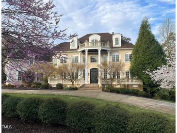 Stately home featuring a columned balcony, brick facade, landscaped yard, and winding driveway at 1000 Clovelly Ct, Raleigh, NC 27614