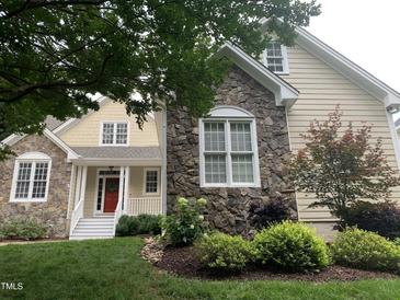 Charming two-story home with stone and vinyl siding and a well-manicured lawn at 1012 Coram Fields Rd, Wake Forest, NC 27587