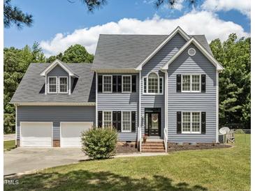 Charming two-story home boasts a manicured lawn, classic shutters, and an attached two car garage at 102 Ridge Ln, Youngsville, NC 27596