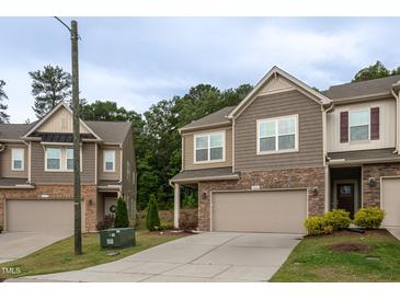 Charming townhome featuring a two-car garage, stone accents, and low-maintenance landscaping at 1048 Flagler St, Durham, NC 27713