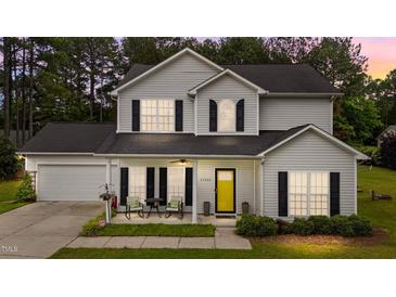 Charming two-story home with light siding, black shutters and a bright yellow front door at 11233 Jeffreys Ln, Wake Forest, NC 27587