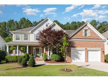 Charming two-story home featuring a brick and siding exterior, a two-car garage, and a beautifully landscaped front yard at 1603 Timber Wolf Dr, Durham, NC 27713