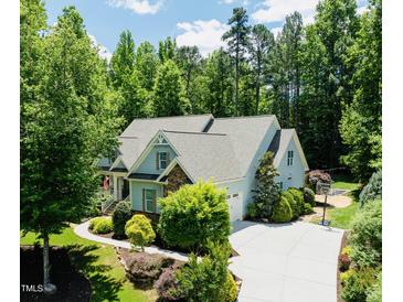 Charming home featuring lush landscaping, a spacious driveway, and a well-maintained yard at 201 Margaret Mann Way, Pittsboro, NC 27312