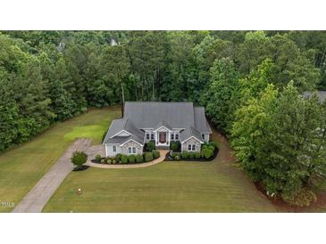 Stunning aerial view of a well-maintained home with lush landscaping and a sprawling lawn surrounded by mature trees at 2208 Wimberly Woods Dr, Sanford, NC 27330
