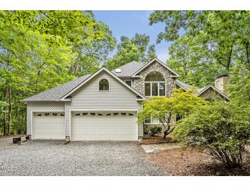 Charming two-story home featuring a stone facade, three-car garage, and lush landscaping at 2606 Sherbrooke Dr, Durham, NC 27712