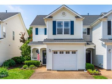 Charming townhouse with blue shutters, a white garage door, and a beautifully landscaped front yard at 2635 Asher View Ct, Raleigh, NC 27606
