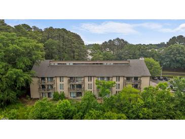 Stunning aerial view of a large, multi-story condo building featuring multiple balconies and nestled amongst lush greenery at 3077 Huntleigh Dr, Raleigh, NC 27604