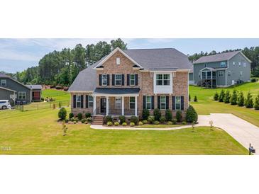Charming two-story brick home featuring a well-manicured lawn and inviting front porch at 367 Tayside St, Clayton, NC 27520