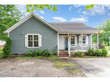 Charming single-story home featuring gray wood shingles, white trim, and a welcoming front porch with a small yard at 4575 Wendell Blvd, Wendell, NC 27591