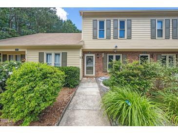 Inviting townhome featuring a landscaped front yard and neutral siding with decorative shutters at 46 Sparger Springs Ln, Durham, NC 27705
