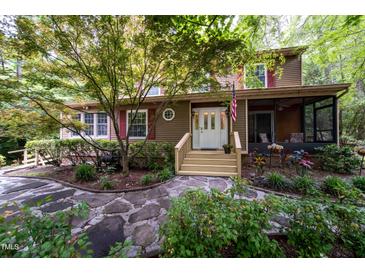 Charming home featuring wood siding, a stone walkway, and a cozy screened-in porch at 4710 Rollingwood Dr, Durham, NC 27713