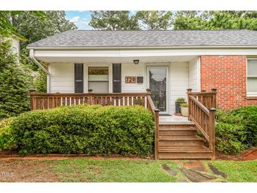 Charming one-story home with a inviting front porch, manicured lawn, and lush landscaping at 729 Mial St, Raleigh, NC 27608