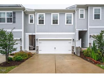 Charming townhome showcasing gray siding, a two-car garage, and manicured landscaping at 1213 Grenshaw Dr, Morrisville, NC 27560