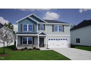 Charming two-story home featuring light blue siding, stone accents, and an attached two-car garage at 135 Cordoba Dr, Franklinton, NC 27525