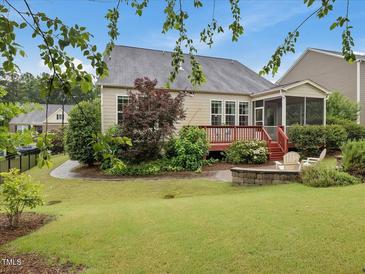 Beautiful backyard with a deck, lush landscaping, and a patio area for outdoor entertaining at 136 Shadow Hawk Dr, Durham, NC 27713