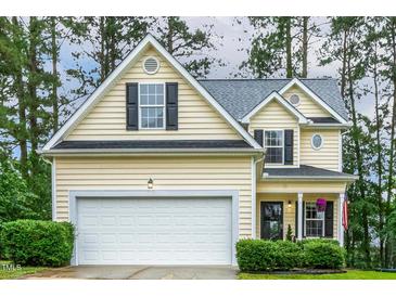 Charming home featuring a two-car garage, manicured lawn, and traditional architectural details at 1984 Sadler Ave, Creedmoor, NC 27522