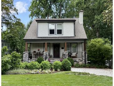Charming two-story home featuring stone accents, a cozy front porch, and professionally landscaped front yard at 2303 Byrd St, Raleigh, NC 27608