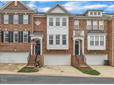Charming brick townhomes featuring attached garages, lovely architectural details, and well-manicured landscaping at 2744 Laurelcherry St, Raleigh, NC 27612