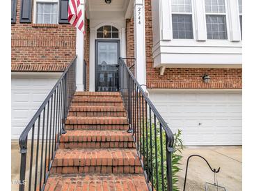 Charming brick townhome with brick steps and a black metal handrail leading to the front door at 2744 Laurelcherry St, Raleigh, NC 27612