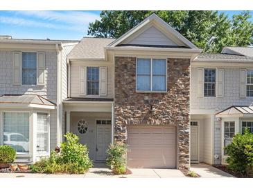 Charming townhouse featuring stone accents, a one-car garage, and well-maintained landscaping at 2822 Pickett Rd # 132, Durham, NC 27705