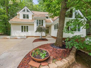 Charming home showcasing a landscaped front yard, tall trees, and bright exterior at 310 Heidinger Dr, Cary, NC 27511