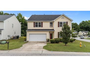 Charming two-story home with a well-maintained lawn and a two-car garage in a suburban neighborhood at 3705 Rivermist Dr, Raleigh, NC 27610