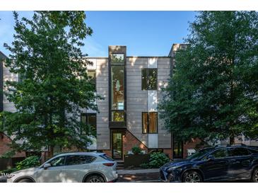 Modern townhome with gray siding, black framed windows, and brick accents, surrounded by lush trees at 414 Chavis Way, Raleigh, NC 27601
