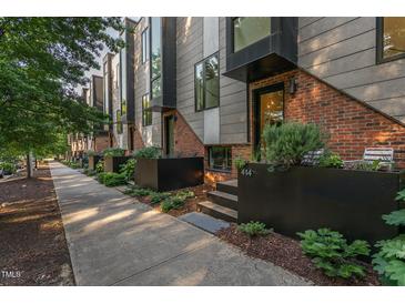 Modern townhome exterior featuring a mix of brick and metal siding, plus attractive planters at 414 Chavis Way, Raleigh, NC 27601