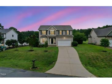 Charming two-story home featuring a well-manicured lawn and inviting curb appeal at twilight at 50 Consella Way, Franklinton, NC 27525