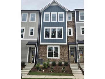 New construction townhome featuring a stone facade, blue accents and crisp white-framed windows at 5029 Jowetts Walk Dr # 29, Cary, NC 27519