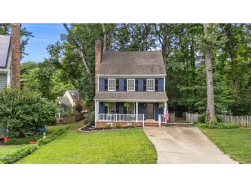 Charming two-story home featuring blue siding, white trim, black shutters and inviting front porch at 6717 Ebon Ct, Raleigh, NC 27615