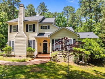Charming two-story home with classic architectural features and beautifully landscaped front yard in a lush neighborhood at 676 Whitehurst, Pittsboro, NC 27312